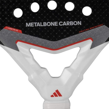 Close-up of a pickleball paddle with 'Metalbone Carbon' branding and Adidas logo.