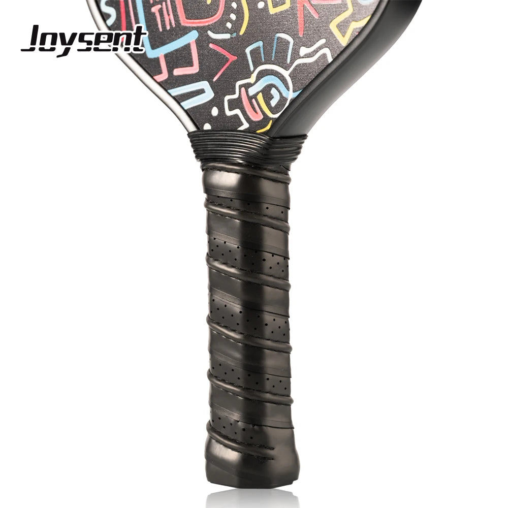 Close-up of a pickleball paddle with colorful designs on the face and black handle.
