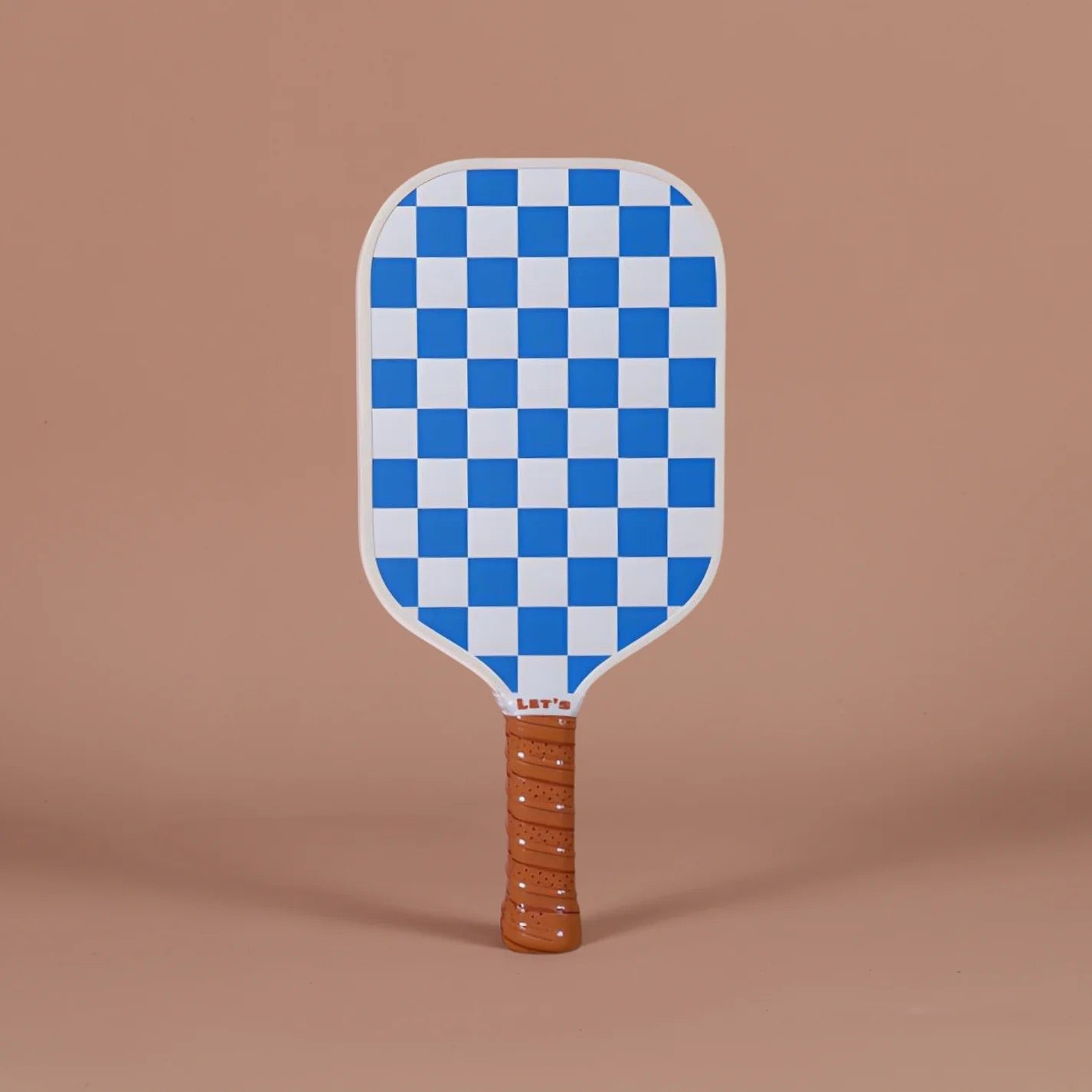 Checkered paddle with a brown handle on a brown background