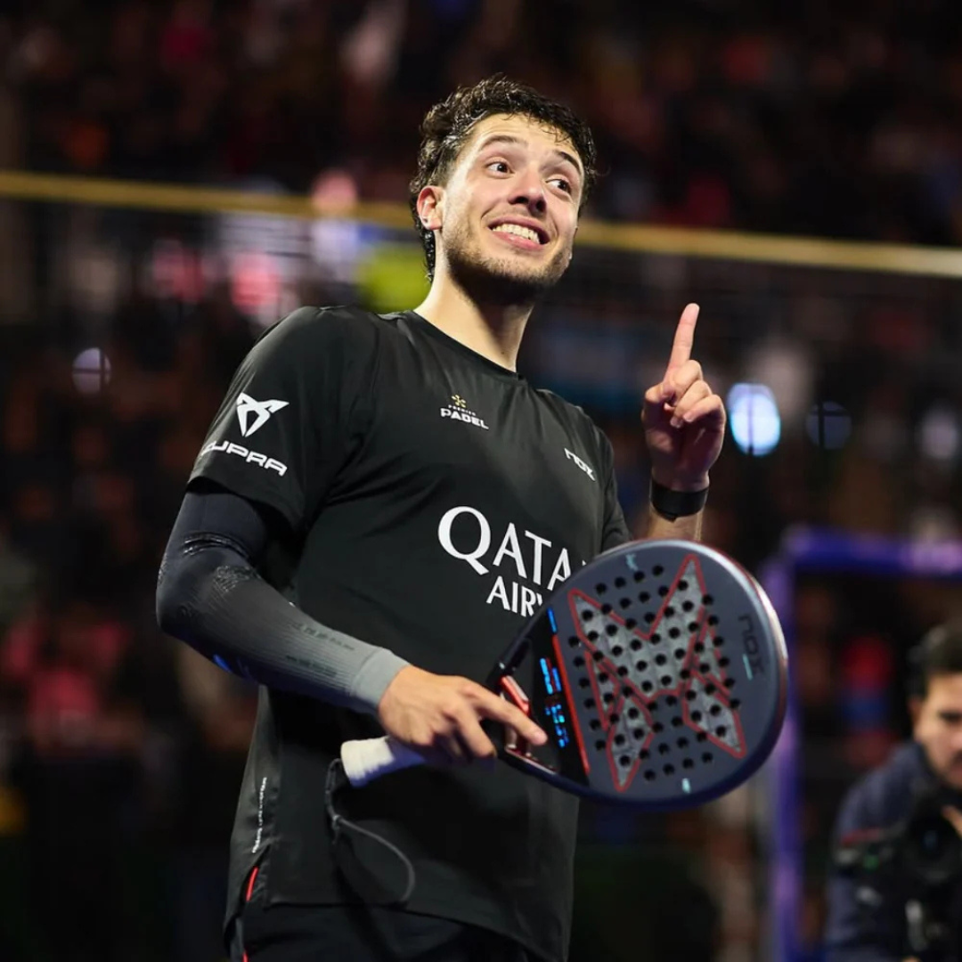 Man holding a paddle with a blurred crowd in the background