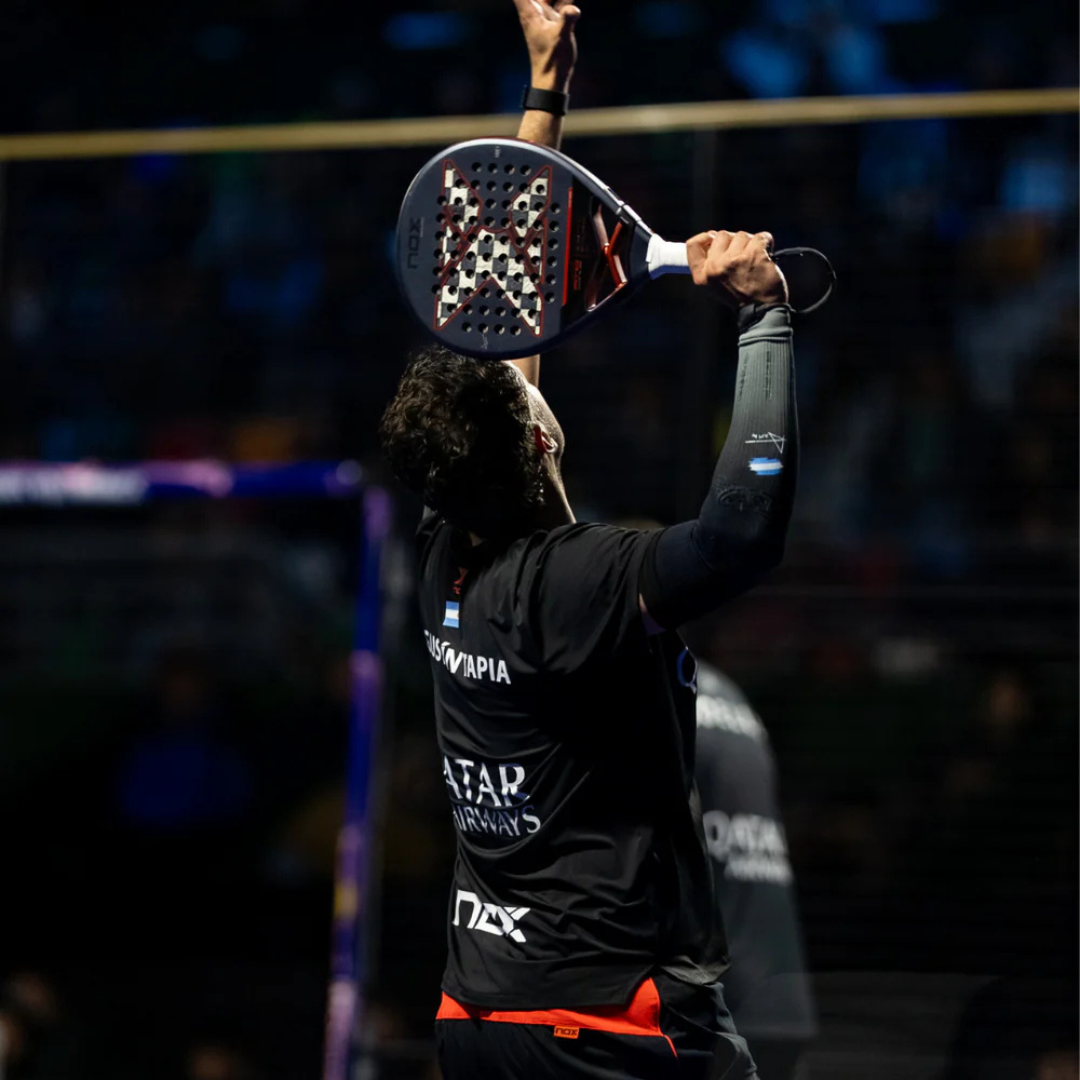 Person holding a paddle above their head in an indoor sports setting