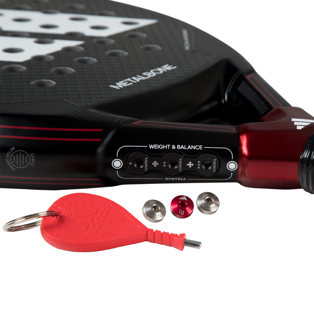 Close-up of a paddle with weight adjustment tools and a red keychain on a white background