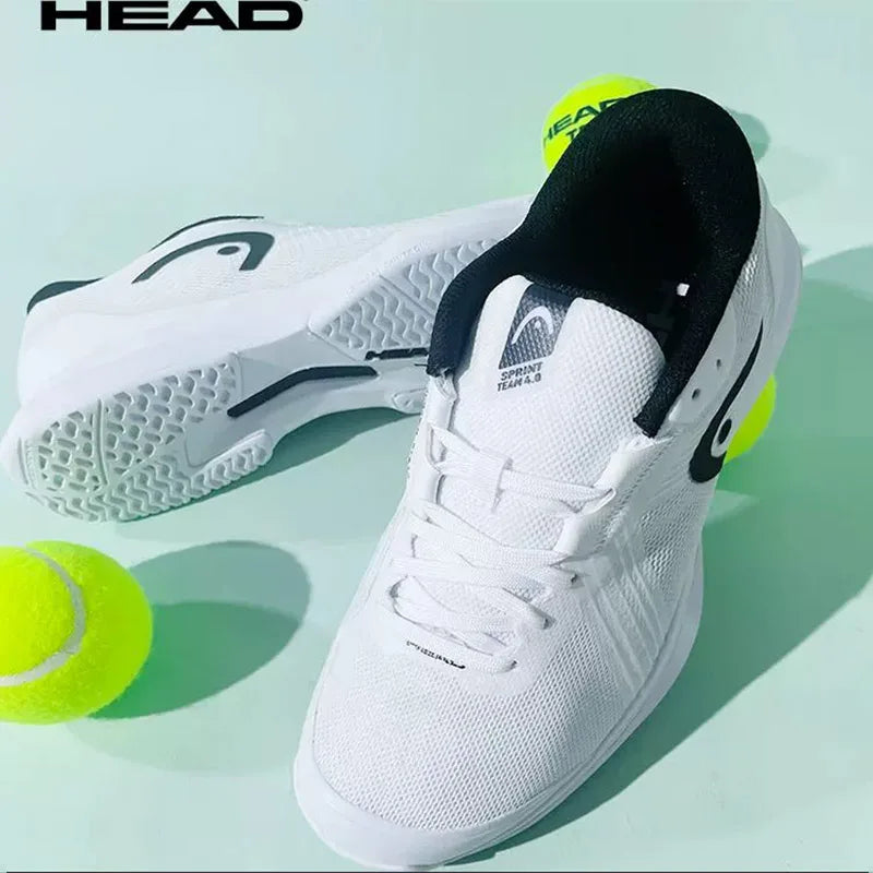 White tennis shoes with black accents and yellow tennis balls on a light green background, featuring the HEAD brand.