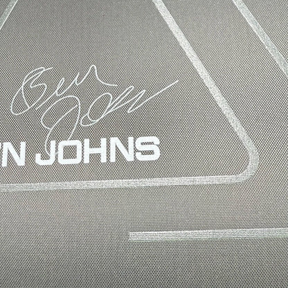Close-up of a vinyl record with 'Ben Johns' branding on a textured gray background