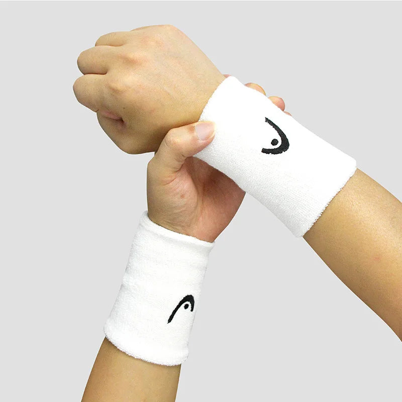 Person wearing a white wristband with a black logo on a light gray background