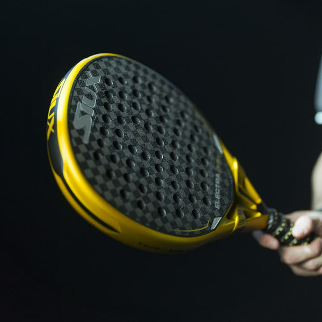Yellow and black Stix paddle held by a person against a dark background