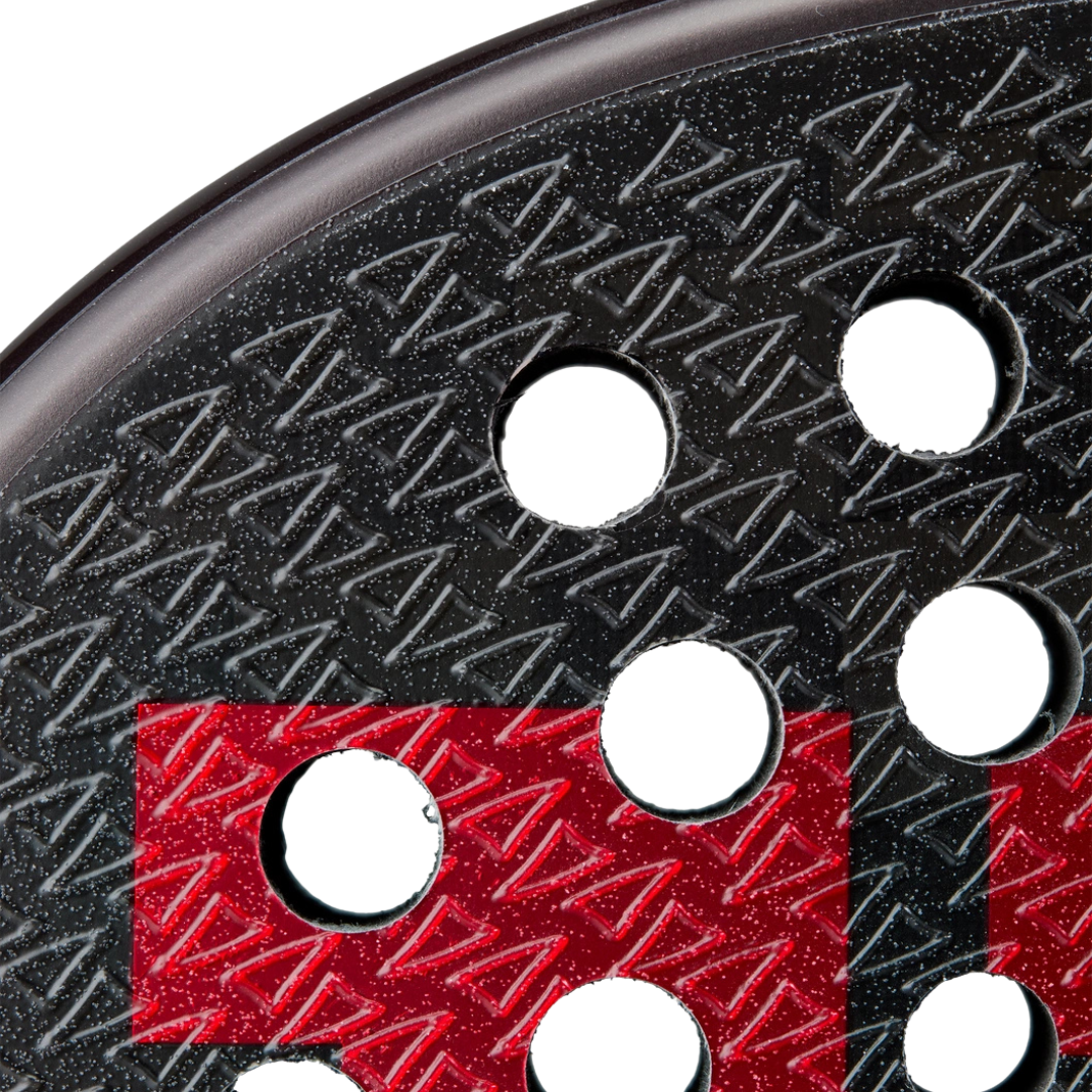 Close-up of a textured black and red circular object with multiple holes.
